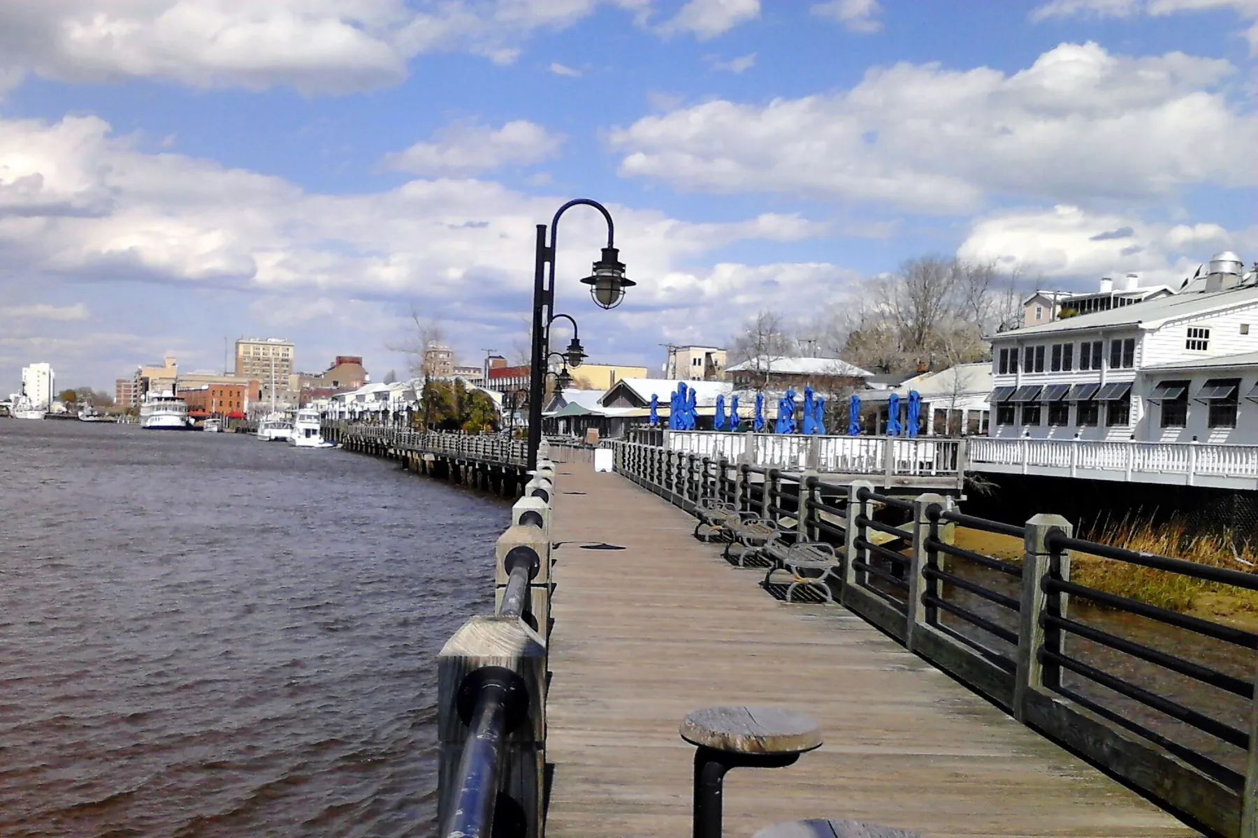 The Riverwalk boardwalk along the Cape Fear River, with downtown Wilmington beyond.