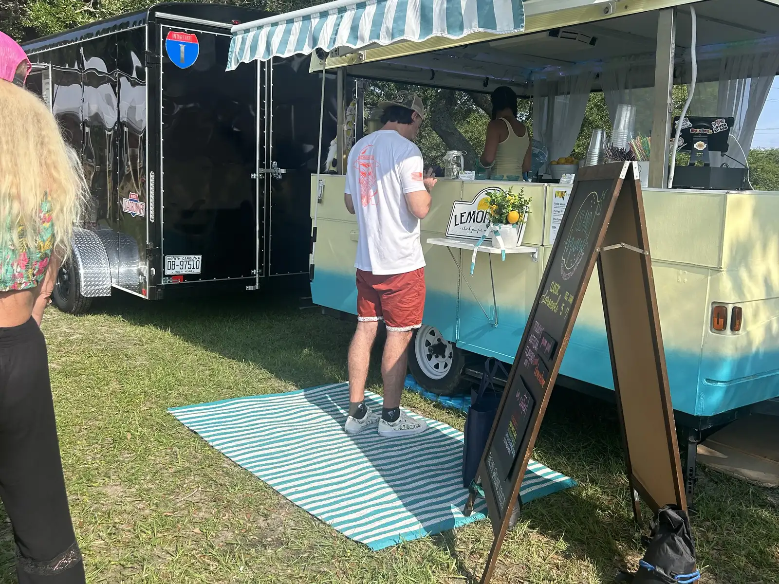 A customer orders from a lemonade trailer at a farmers market in Wilmington