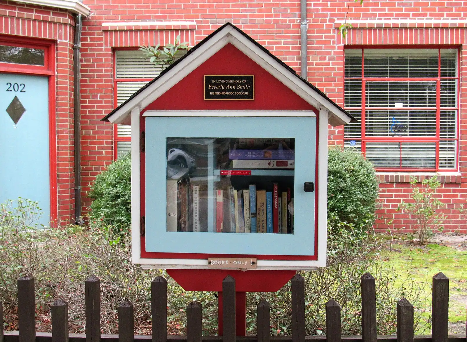 A Little Free Library in front of a brick home in a Wilmington neighborhood