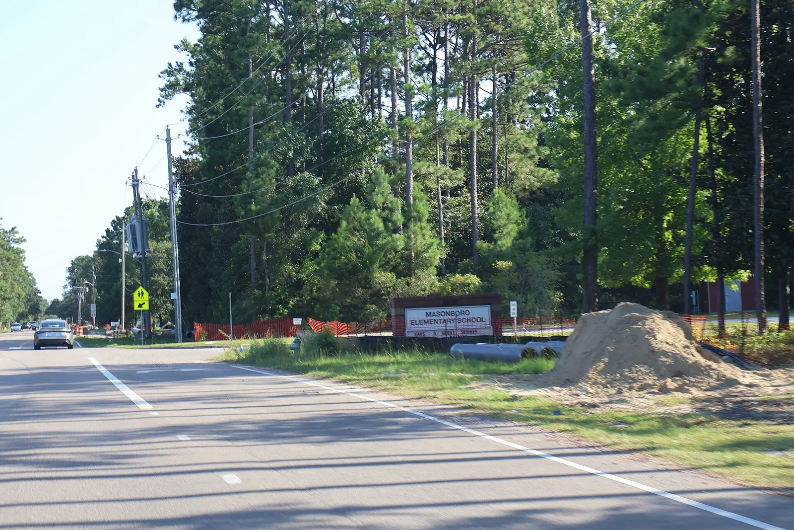 The Masonboro Elementary School sign beside Masonboro Loop Road in Wilmington, with the campus behind the pines