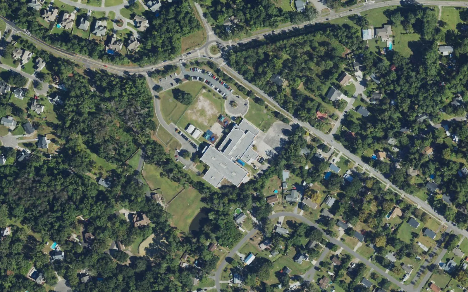 Ogden Elementary School off Middle Sound Loop Road, seen from the air, with wooded neighborhoods around it