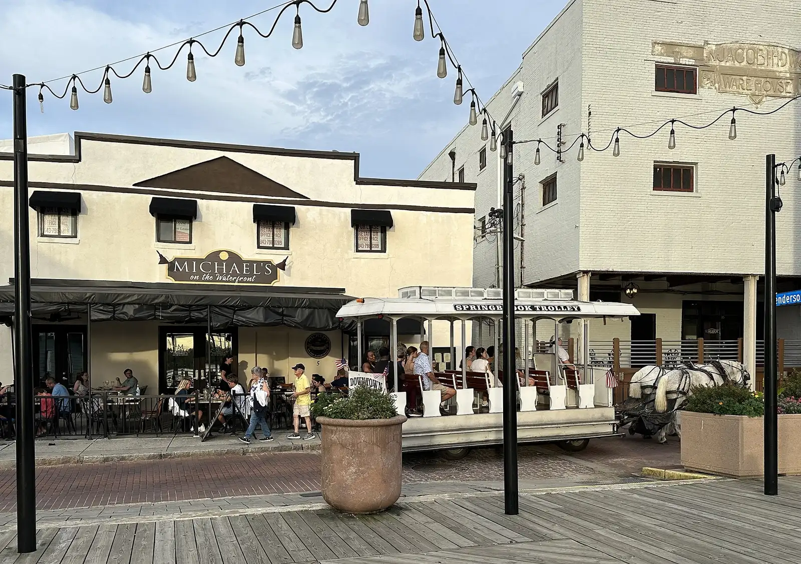 A horse-drawn trolley passes diners outside Michael's on the Waterfront beside the Riverwalk in downtown Wilmington