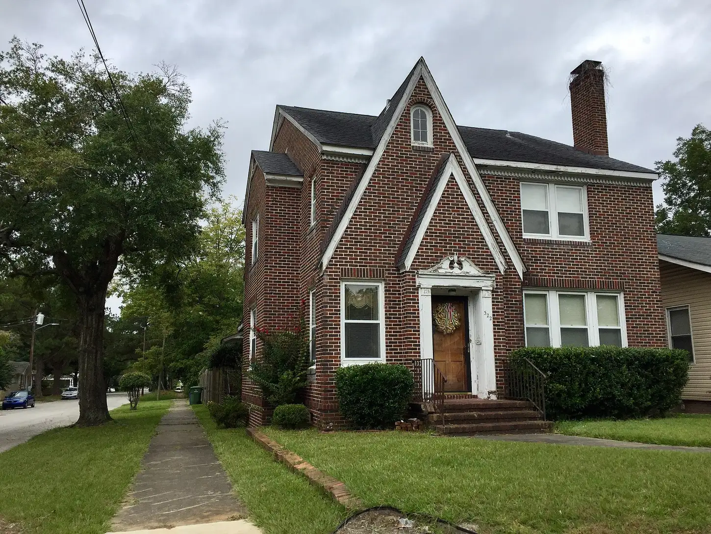A brick house with a wreath on the door on a tree-lined street in Wilmington's Westbrook-Ardmore neighborhood